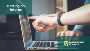 An office setting with people working. Highlight on a laptop and some pointing at the screen